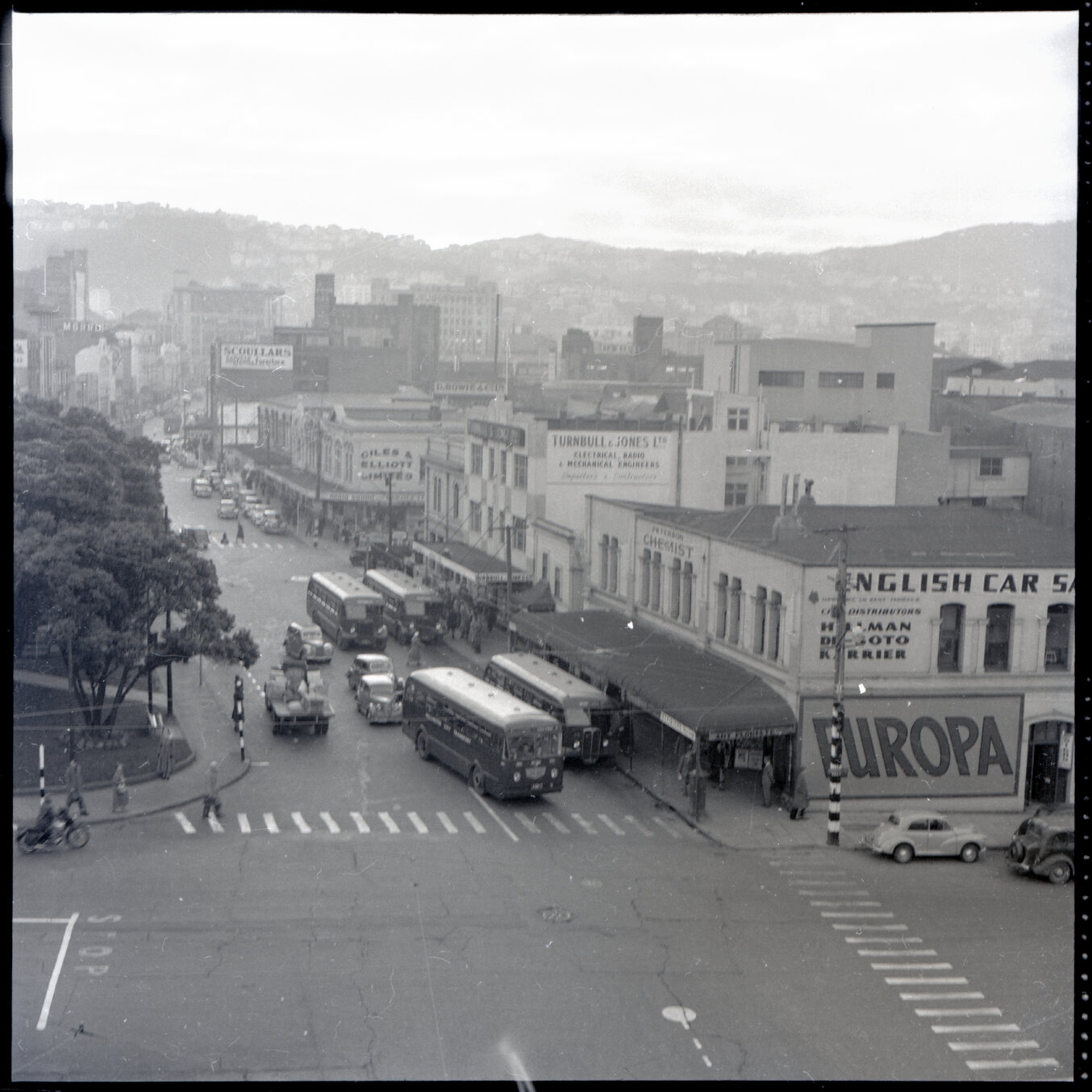 b. Elevated views of Courtenay Place, Cambridge and Kent Terrace from the top of the Embassy Theatre. Mens Toilet / Taj Mahal Restaurant, Tramcars, motor vehicles, Queen Victoria Statue, Cambridge Hotel 