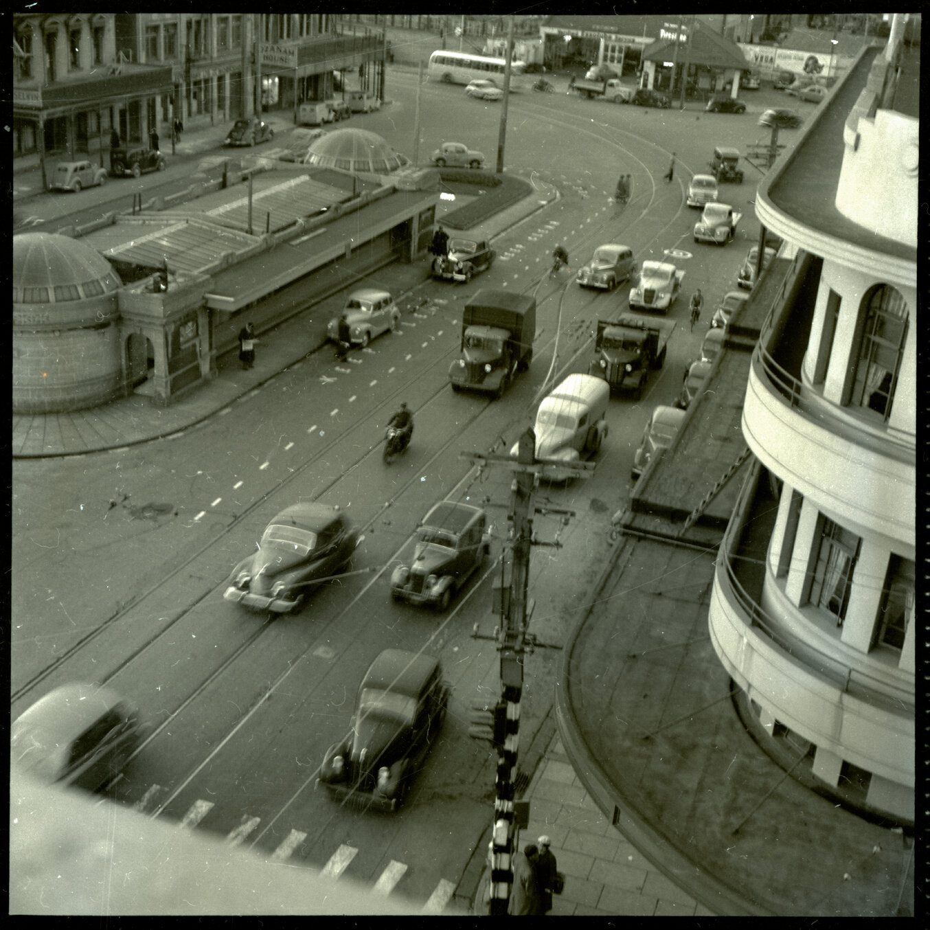 c. Elevated views of Courtenay Place, Cambridge and Kent Terrace from the top of the Embassy Theatre. Mens Toilet / Taj Mahal Restaurant, Tramcars, motor vehicles, Queen Victoria Statue, Cambridge Hotel 