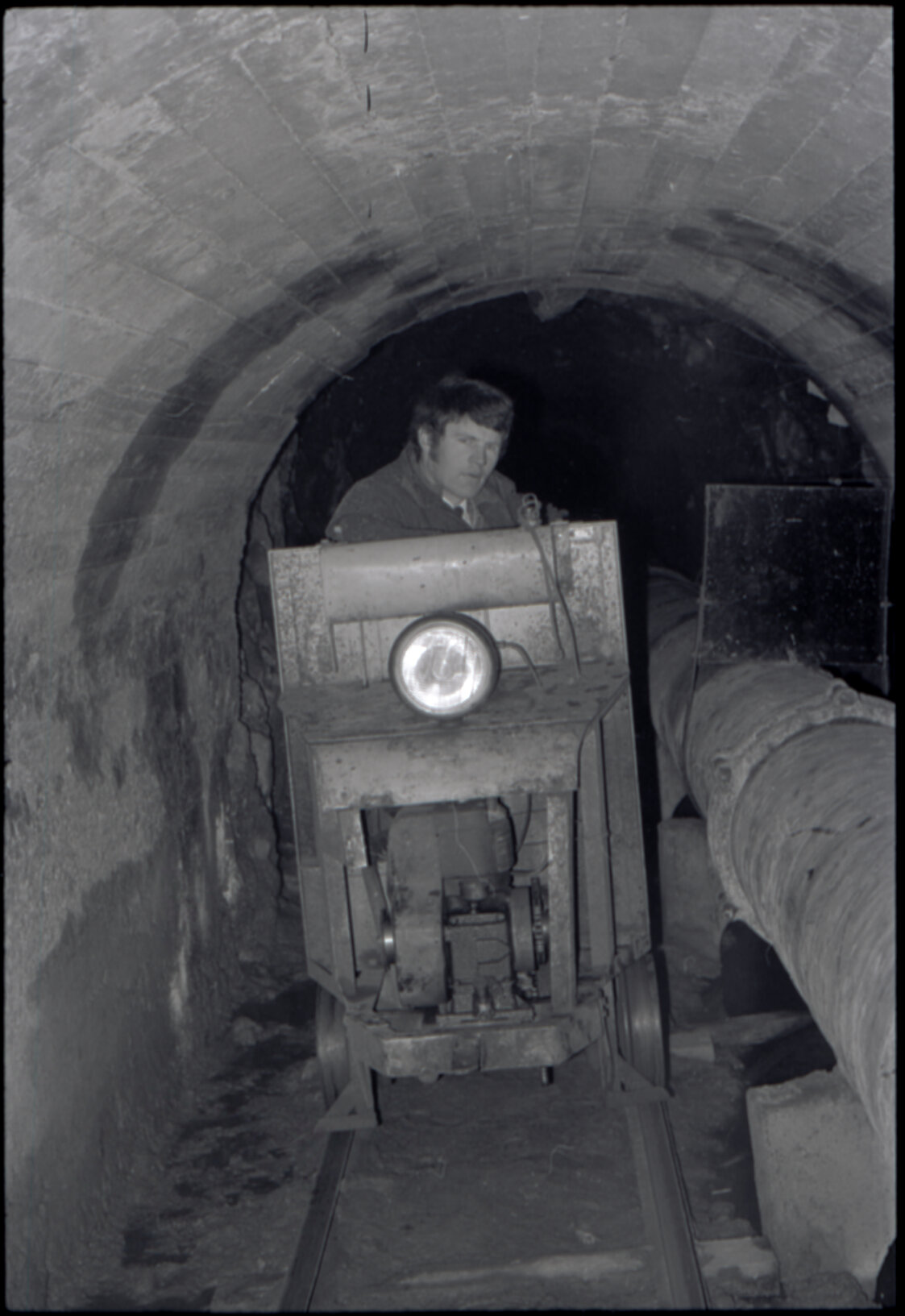 Orongorongo and Wainuiomata water catchment area, worker in a tunnel next to a pipe