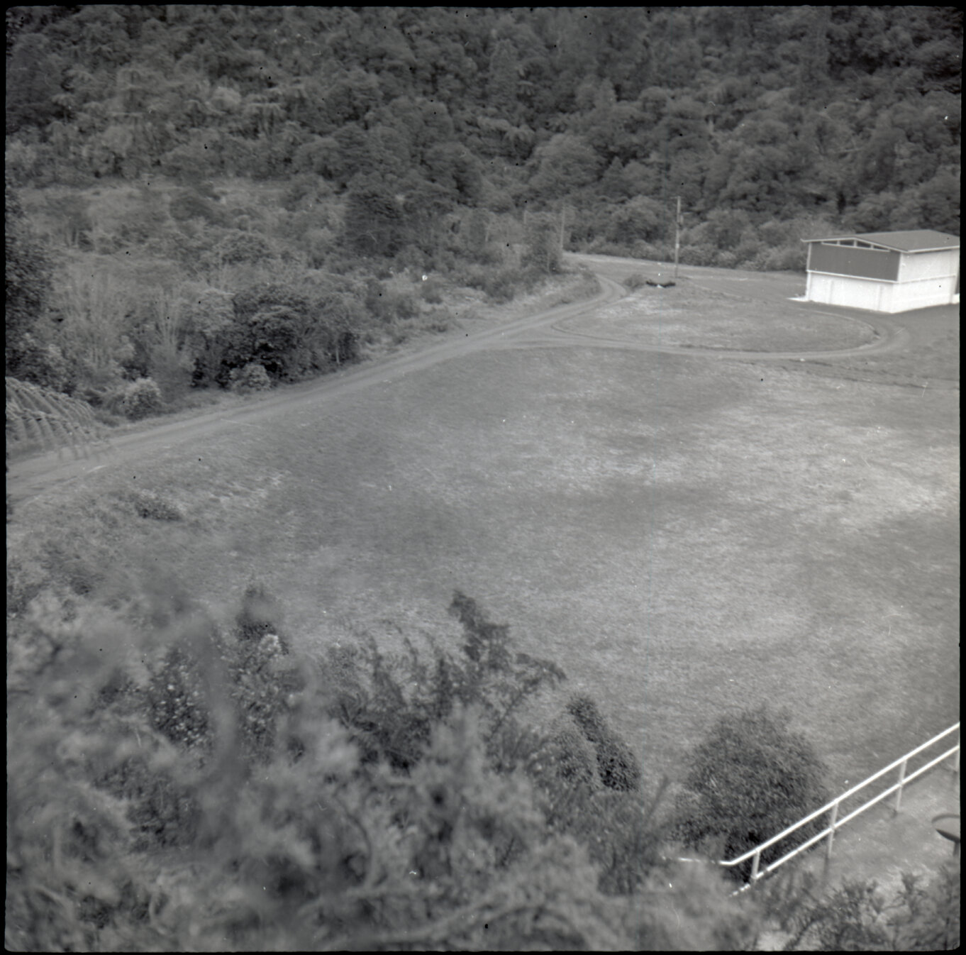 Orongorongo and Wainuiomata water catchment area, grassy area and building next to the dam