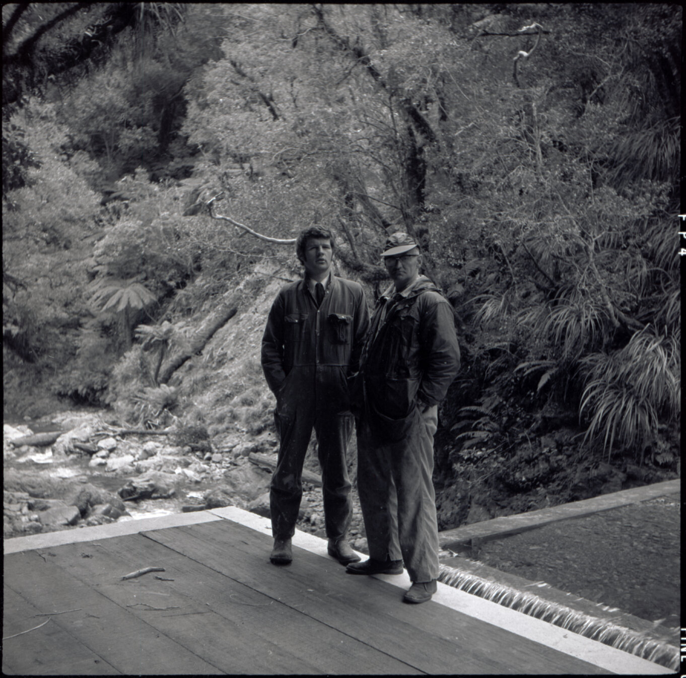 Orongorongo and Wainuiomata water catchment area, two workers on a platform in front of a dam