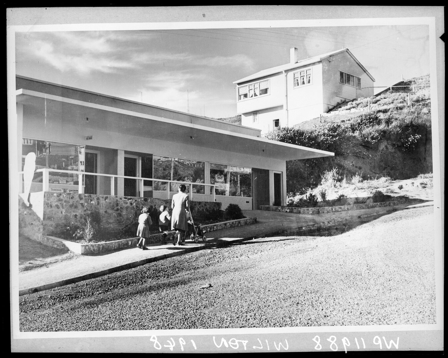 Mother and children walking past newly constructing shops, Wilton