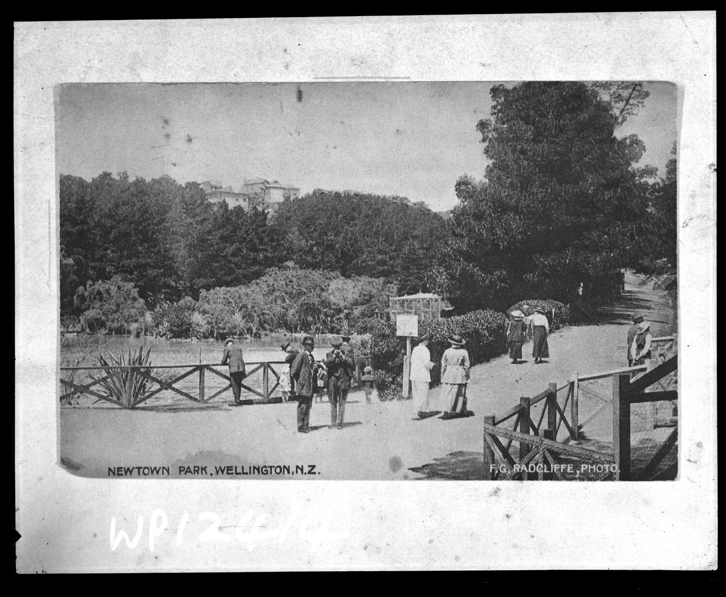 People walking past lake, Newtown Park