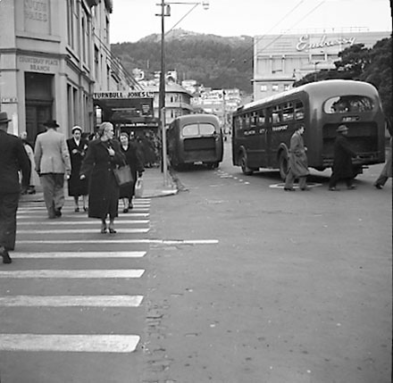 a. Pedestrians crossing road at corner of Courtenay Place and Blair Street. Diesel buses at bus stop in background