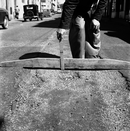 a. Workman pointing out damage / subsidence to road surface