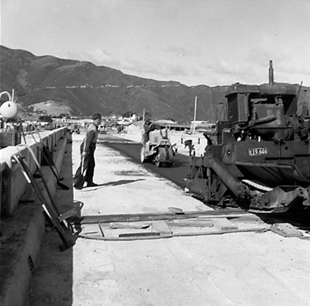 e. Construction of new bridge, workmen, machinery, motor vehicles. Road is being resurfaced