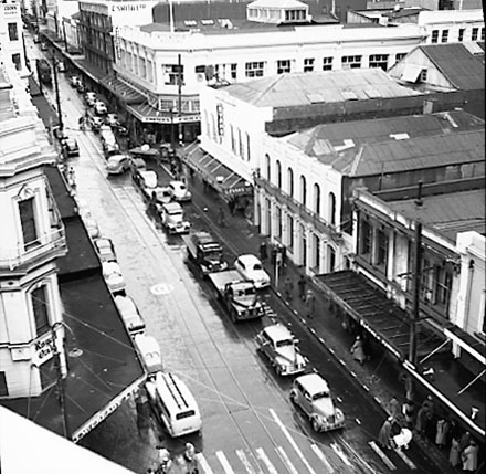 b. Elevated view of Manners Street from James Smith Corner. Bank of New Zealand on corner of Cuba Street. Motor vehicles and tramcars