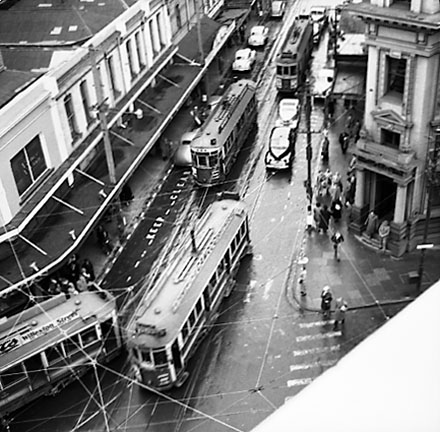 a. Elevated view of Manners Street from James Smith Corner. Bank of New Zealand on corner of Cuba Street. Motor vehicles and tramcars