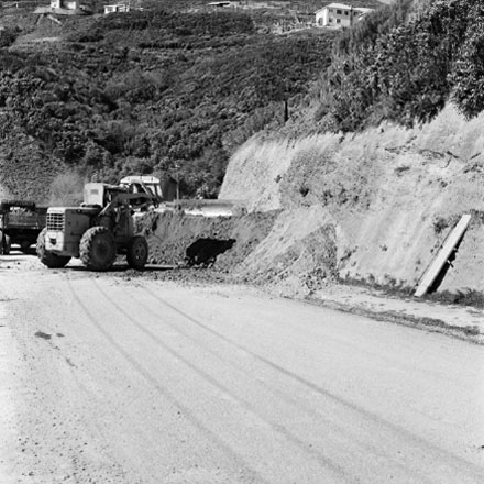 a. Workmen are using machinery to clear piles of gravel