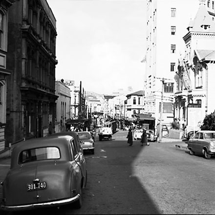 b. From the south end of Boulcott Street, looking towards the Manners and Willis Street intersection. Boulcott Chambers building on the left, YWCA and the St George Hotel on the right. Motor vehicles