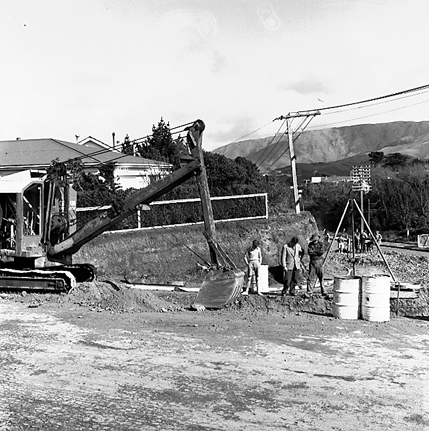 a. Workmen in trench laying pipes