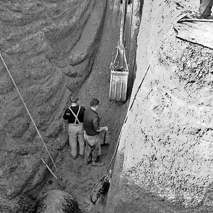 d. Workmen in trench laying pipes