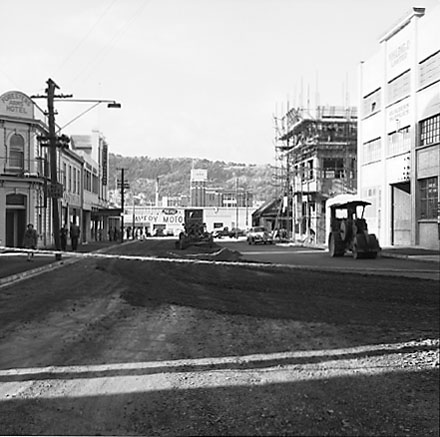 d. From the corner of Leeds Street, Ghuznee Street is being resurfaced. Buildings, motor vehicles, workmen