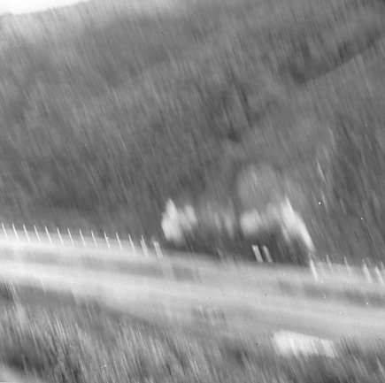 l. Possibly explosives being used to demolish a portion of the hillside. Workmen are preparing site. Elevated view of site with large cloud of dust