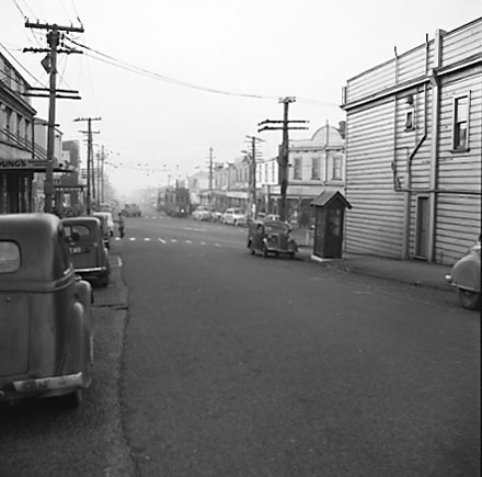a. Looking north. Motor vehicles, tramcars, shops