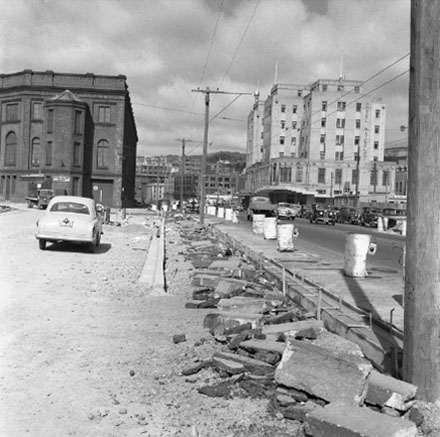 b. Asphalt has been dug up. Shed 21 and Waterloo Hotel are in the background. Motor vehicles