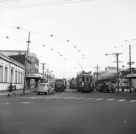 b. Rugby Street intersection, tramcars, pedestrians, motor vehicles, commercial buildings
