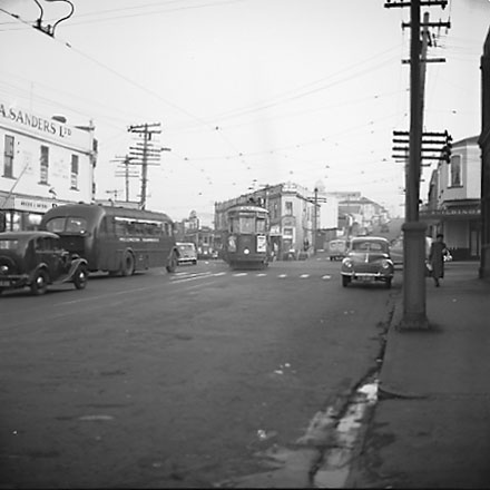 c. John Street and Riddiford Street intersection, pedestrians, tramcars, motor vehicles, retail buildings