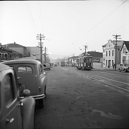 f. John Street and Riddiford Street intersection, pedestrians, tramcars, motor vehicles, retail buildings
