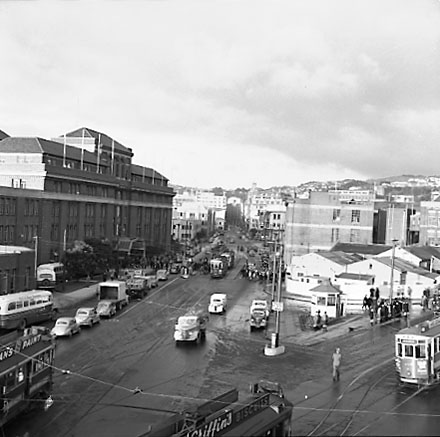 b. Elevated view of Railway Tram Terminus on Thorndon Quay / Featherston Street - people waiting for trams, buses, motor vehicles