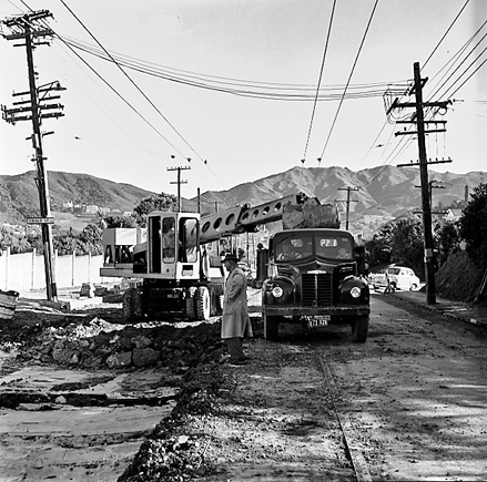 b. Road works, workmen and associated machinery, front end tractor, roller, grader, crane, trucks, motor vehicles