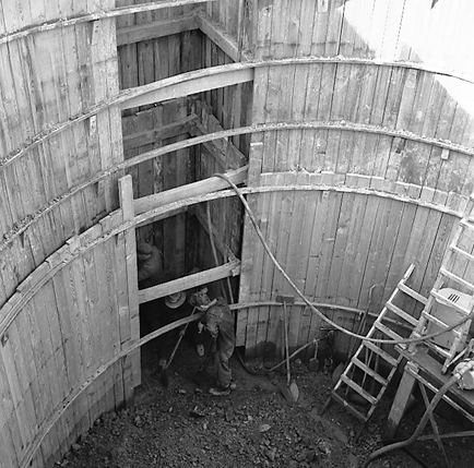 b. Interior views of. Workmen constructing underground pumping station