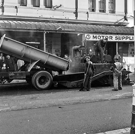 c. Looking east from Cuba Street to Taranaki Street intersection. Workmen are using an asphalt laying machine to re surface the road