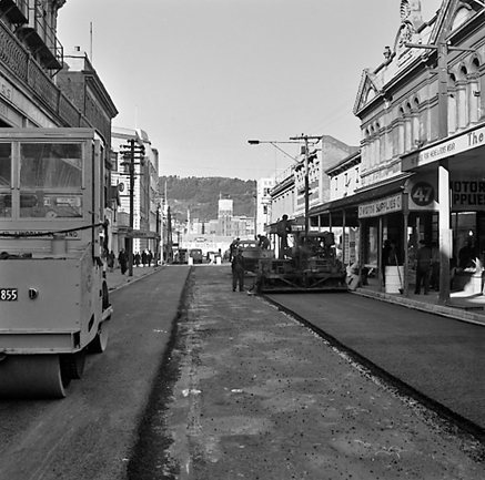 d. Looking east from Cuba Street to Taranaki Street intersection. Workmen are using an asphalt laying machine to re surface the road