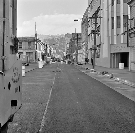 i. Looking east from Cuba Street to Taranaki Street intersection. Workmen are using an asphalt laying machine to re surface the road
