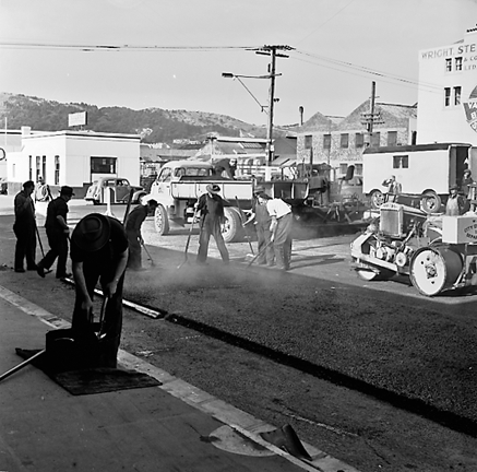 l. Looking east from Cuba Street to Taranaki Street intersection. Workmen are using an asphalt laying machine to re surface the road