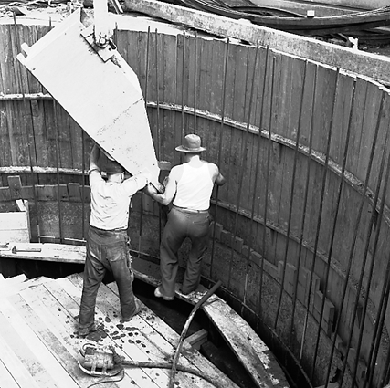 a. Workmen using a concrete mixer truck to pour concrete