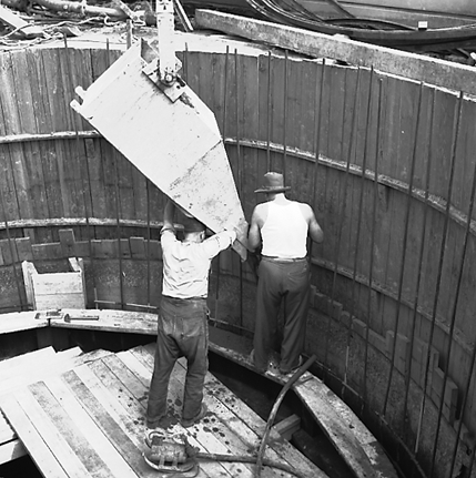 d. Workmen using a concrete mixer truck to pour concrete