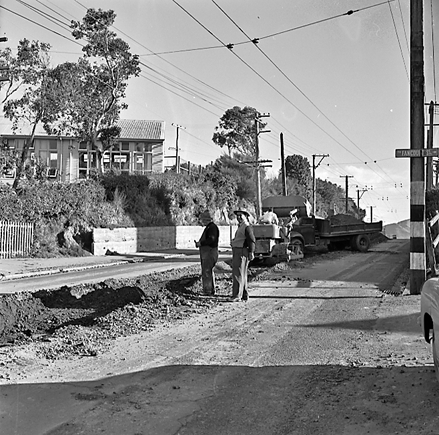 b. Views of workmen re surfacing the road. Machinery and motor vehicles