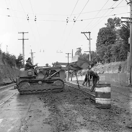 f. Views of workmen re surfacing the road. Machinery and motor vehicles