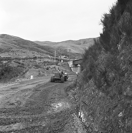 a. views of construction work in progress, workmen, equipment, graders, front end loaders, trucks, dwellings in the background