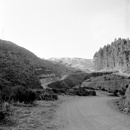 e. views of construction work in progress, workmen, equipment, graders, front end loaders, trucks, dwellings in the background
