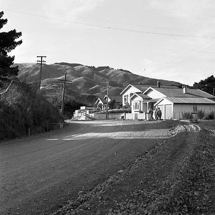 n. views of construction work in progress, workmen, equipment, graders, front end loaders, trucks, dwellings in the background