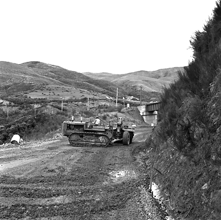 p. views of construction work in progress, workmen, equipment, graders, front end loaders, trucks, dwellings in the background