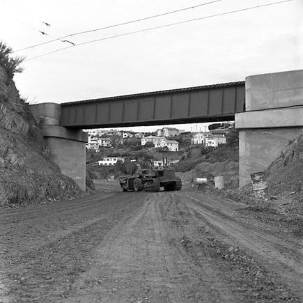 r. views of construction work in progress, workmen, equipment, graders, front end loaders, trucks, dwellings in the background