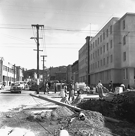 e. Various views of Taranaki Street road works. Includes Traffic Offices directing traffic, the Panama Hotel on the corner of Vivian Street, Wright Stevenson Building, workmen and equipment, and motor vehicle