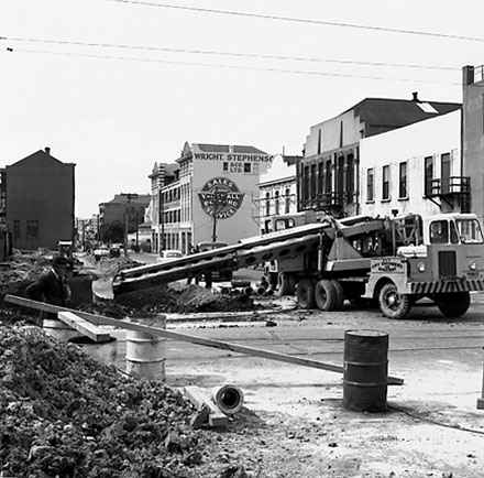 i. Various views of Taranaki Street road works. Includes Traffic Offices directing traffic, the Panama Hotel on the corner of Vivian Street, Wright Stevenson Building, workmen and equipment, and motor vehicle