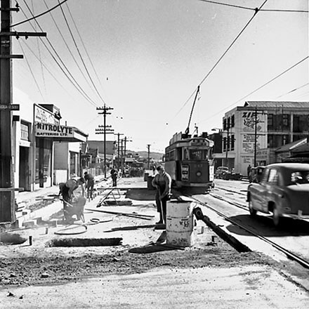 a. Workmen working on road in foreground, tramcar bound for Railway Station in background