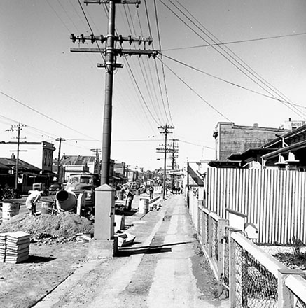 b. Workmen working on road in foreground, looking south along Adelaide Road in background