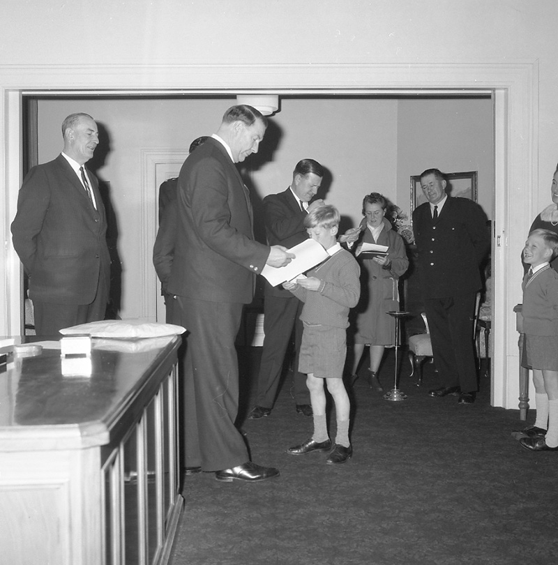 g. Mayor's room, boy presenting plaque to Mayor