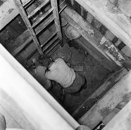 e. Interior of drainage tunnel, workman inside drainage tunnel