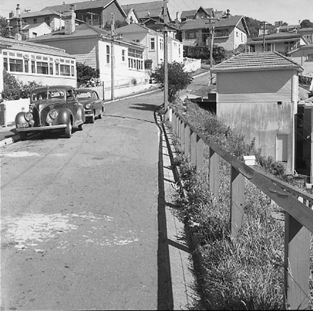 b. Views of dwelling that has been affected by a slip. Concrete retaining wall has fallen over against the house