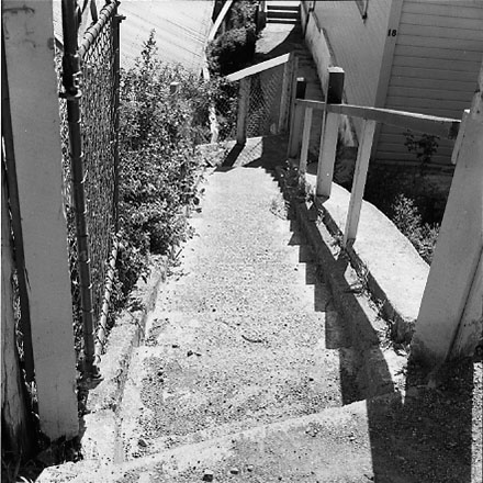 c. Views of dwelling that has been affected by a slip. Concrete retaining wall has fallen over against the house