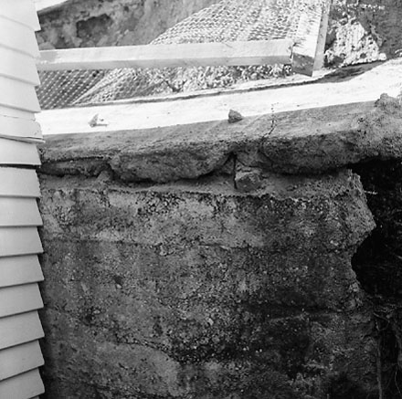 k. Views of dwelling that has been affected by a slip. Concrete retaining wall has fallen over against the house