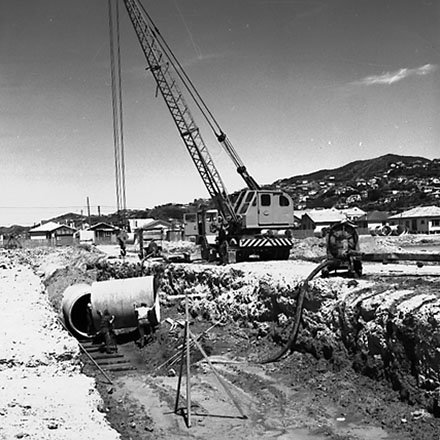 c. Workmen are using a crane to manouver drainage pipes into place