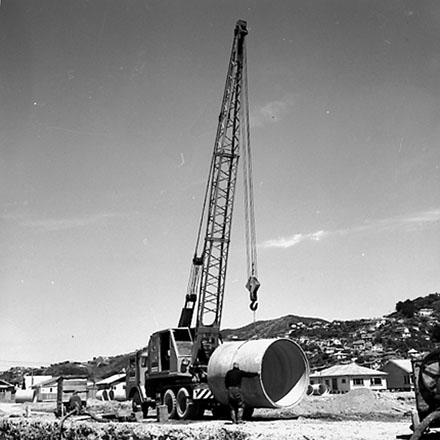 d. Workmen are using a crane to manouver drainage pipes into place
